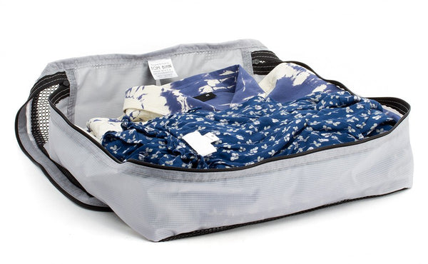 A few button-down shirts folded in an open Northwest Sky (light grey) Large Aether Aeronaut 45 Packing Cube.